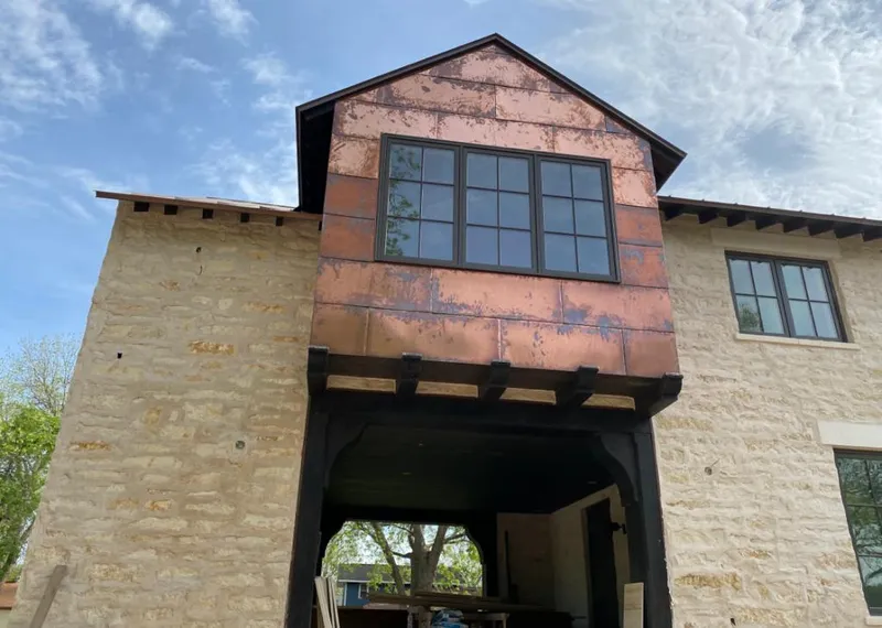 Copper metal panel facade on a stone building for Metal Roof Coating in Castle Pines Village
